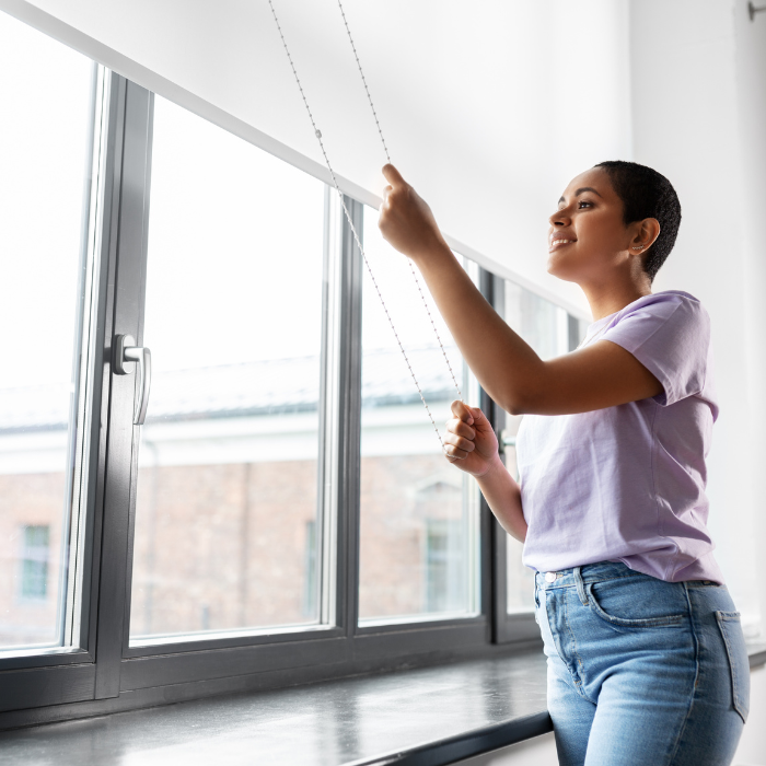 A woman closing the blinds